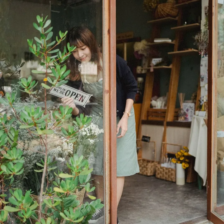A shop owner turning the sign to open